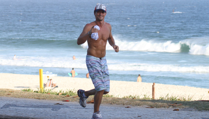 Ex-BB Fael corre pela praia em dia de sol no Rio