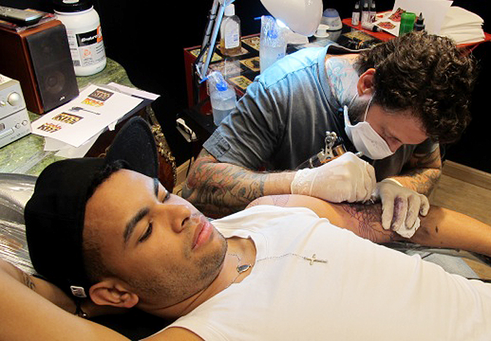 Dentinho faz tatuagem e Dani Souza fica o tempo todo ao seu lado