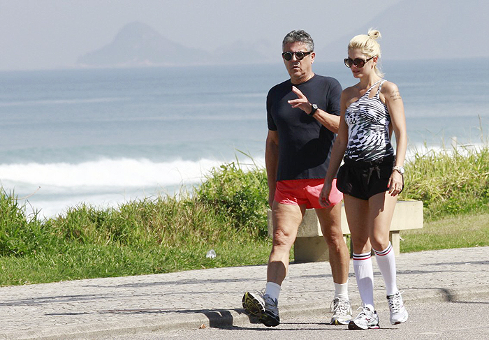 Marcos Paulo caminha de short rosa com a mulher