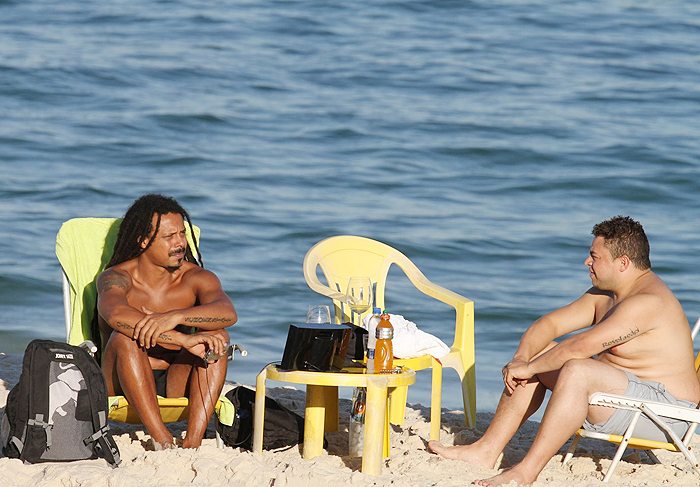 Marcelo Falcão toma vinho na taça em dia na praia