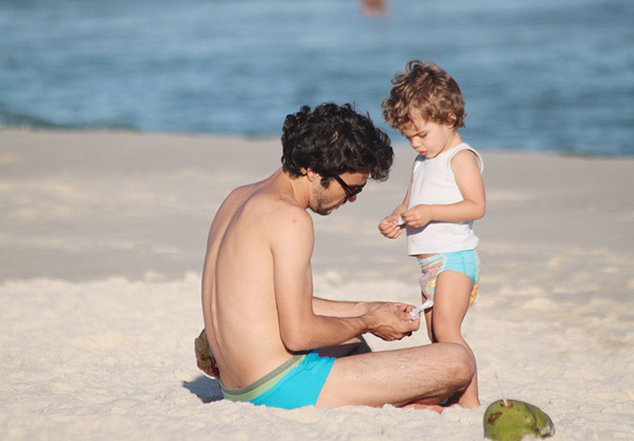 Caio Blat leva o filho Bento à praia em final de tarde ensolarado