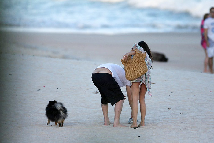 Ísis Valverde dá gargalhada com namorado e cachorro na praia