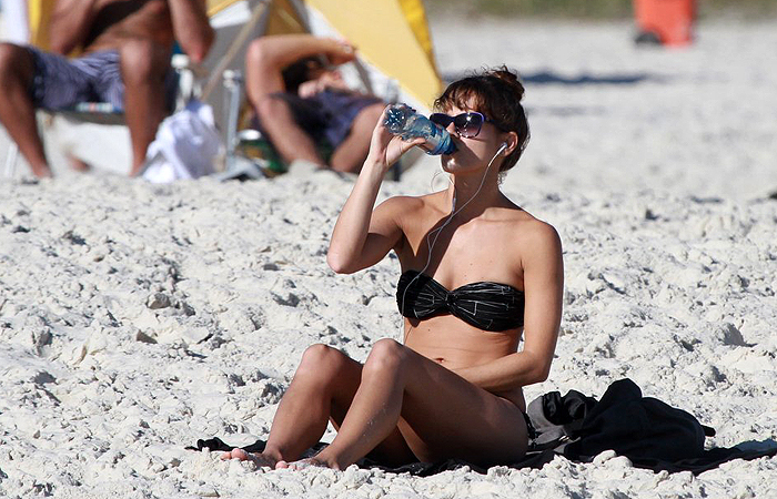 Sozinha, Fernanda de Freitas toma sol em praia carioca