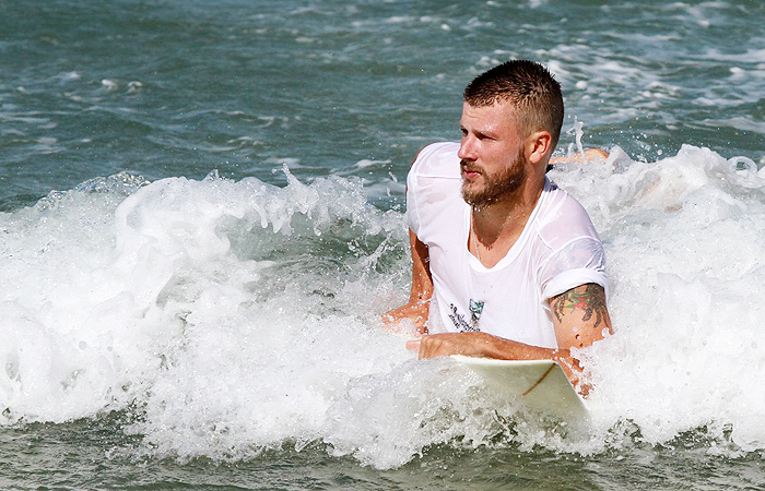 Rodrigo Hilbert surfa em praia carioca