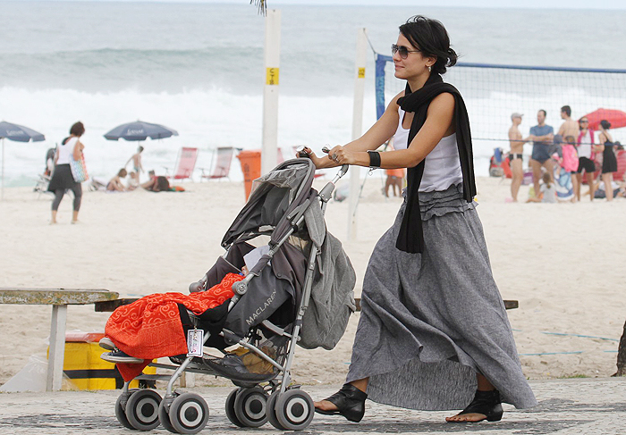 Juliana Knust passeia na praia com o filho dormindo
