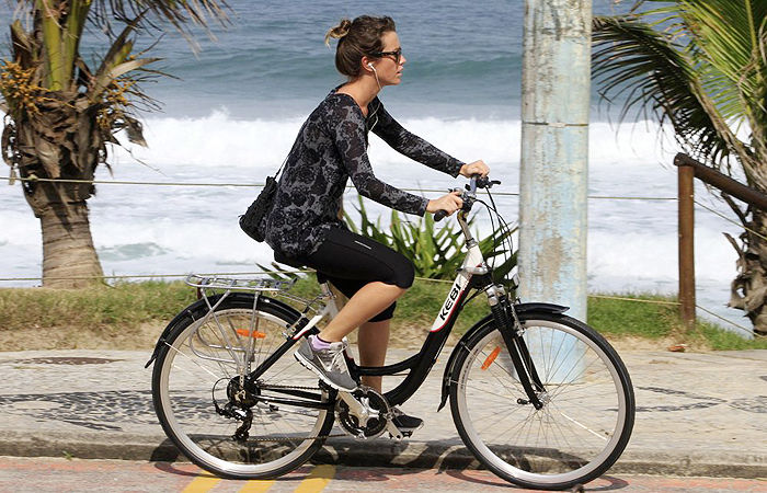 Juliana Didone curte música ao pedalar pela Barra da Tijuca