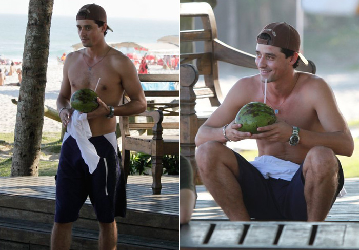Ex-BBB Fael toma água de coco sozinho na praia