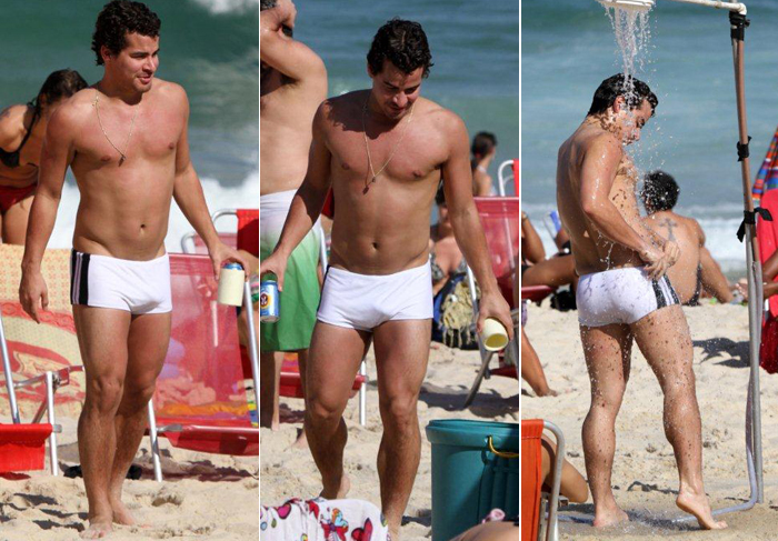 Thiago Martins desfila de sunga branca pela praia do Leblon