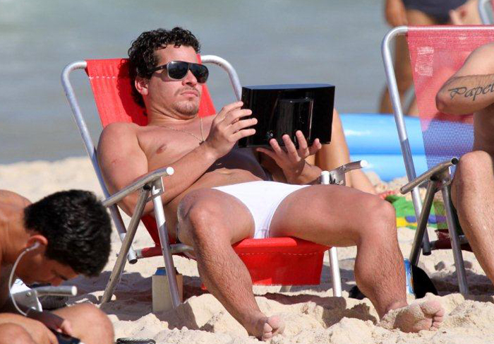 Thiago Martins desfila de sunga branca pela praia do Leblon