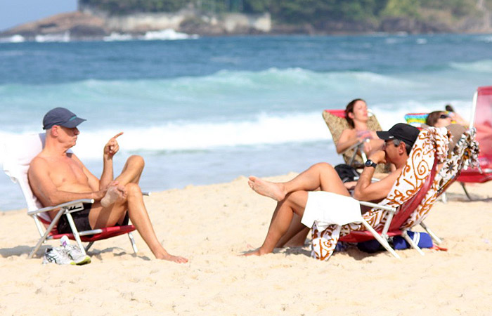 Marcos Caruso curte papo com amigos na praia no Rio