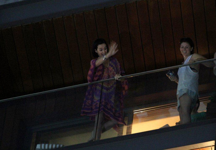 Katy Perry faz gestos para fãs da sacada do hotel
