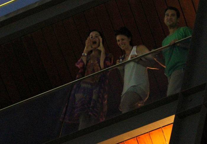 Katy Perry faz gestos para fãs da sacada do hotel