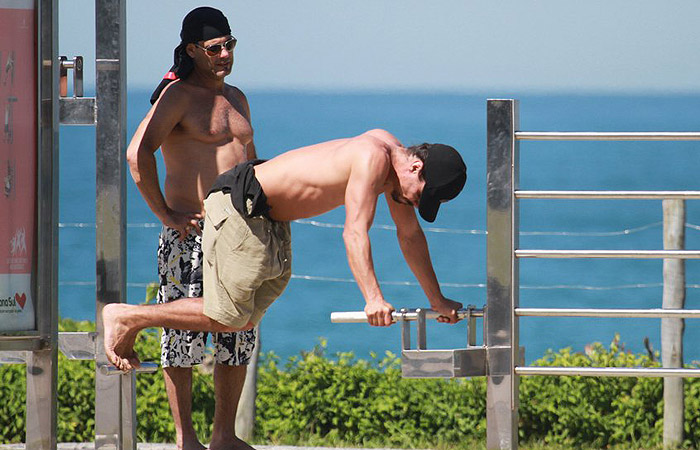 André Gonçalves se exercita ao lado de amigo na praia do Recreio