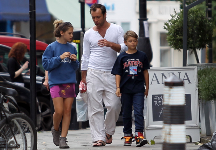 Jude Law usa look despojado durante passeio com os filhos