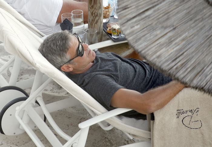 George Clooney relaxa em cadeira de praia na Córsega, na França