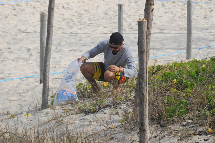 Paulinho Vilhena recolhe lixo na praia