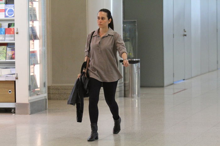 Alessandra Negrini passa apressada por saguões de aeroporto