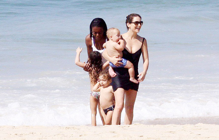 Claudia Abreu se diverte com os filhos na praia do Leblon