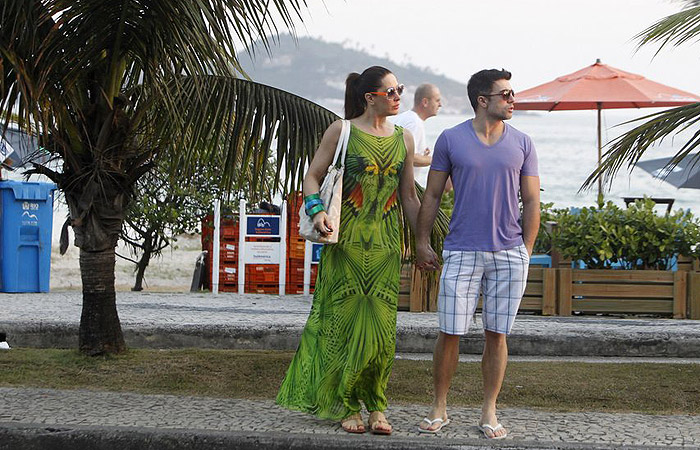 Claudia Raia toma água de coco com namorado em praia carioca
