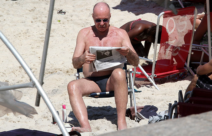 Gilberto Braga mostra o cofrinho em praia no Rio de Janeiro