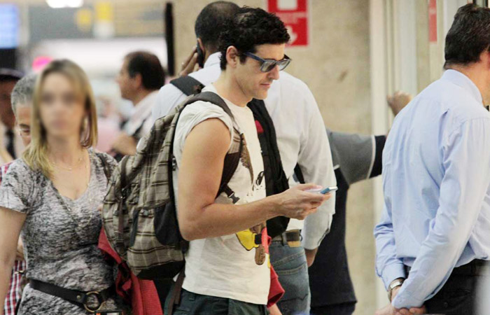 Reynaldo Gianecchini não larga o celular em aeroporto de São Paulo