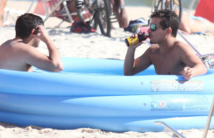 Thiago Martins toma banho de piscininha plástica na praia