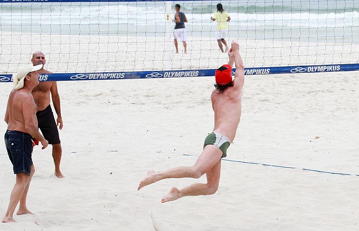 Marcello Novaes pula e rola na areia em jogo de vôlei de praia