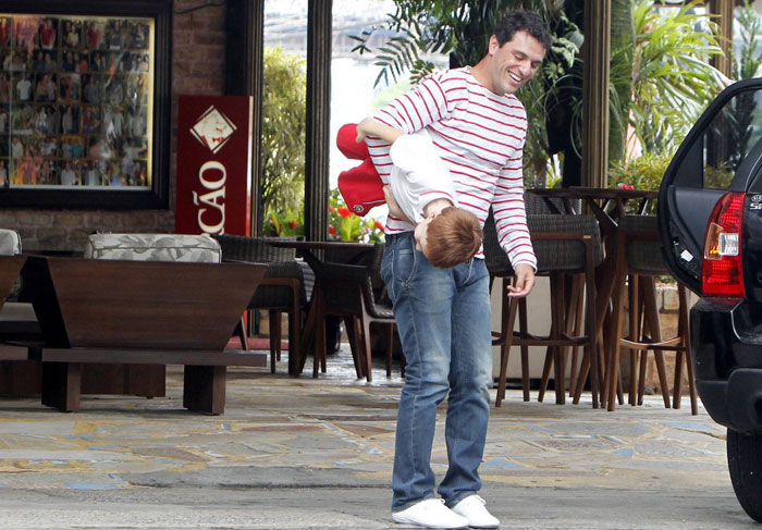 Rodrigo Lombardi carrega o filho quase que de ponta-cabeça