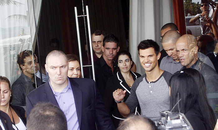 Taylor Lautner distribui autógrafos na porta de hotel, no Rio