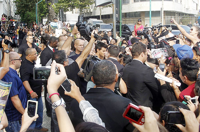 Taylor Lautner distribui autógrafos na porta de hotel, no Rio