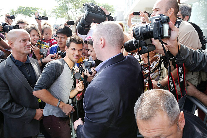 Taylor Lautner distribui autógrafos na porta de hotel, no Rio