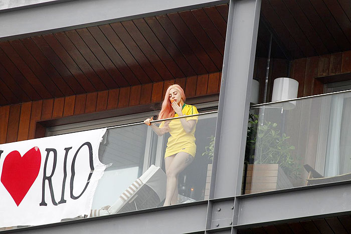 Lady Gaga aparece na sacada do hotel com cabelo rosa e camisa do Brasil