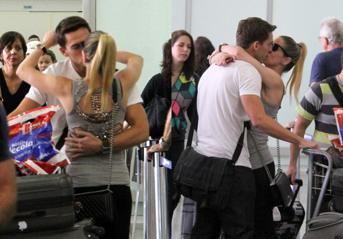 Danielle Winits recepciona namorado em aeroporto com beijos e abraços