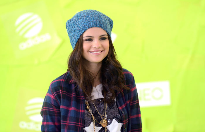 Selena Gomez surge sorridente em lançamento de moda