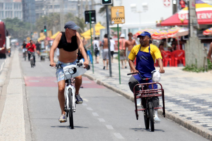 Marcos Caruso anda de bicicleta ao lado de entregador no Rio