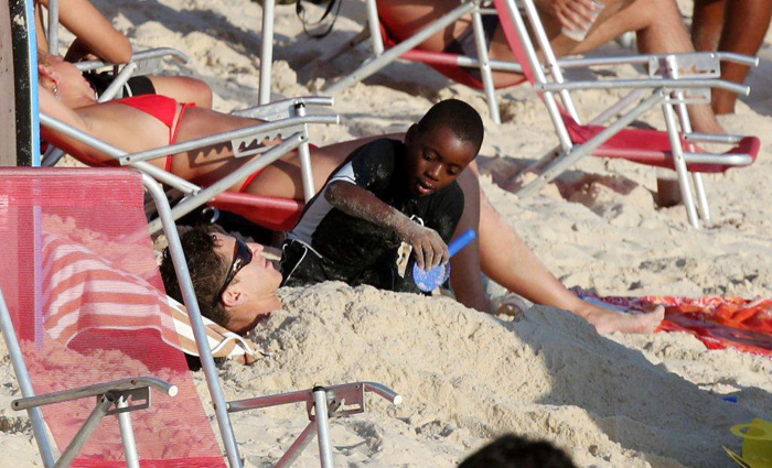 Filhos de Madonna praticam bodyboard em praia carioca