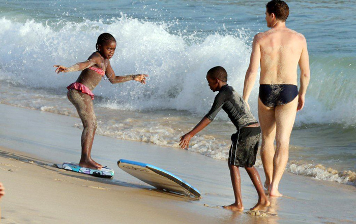 Filhos de Madonna praticam bodyboard em praia carioca