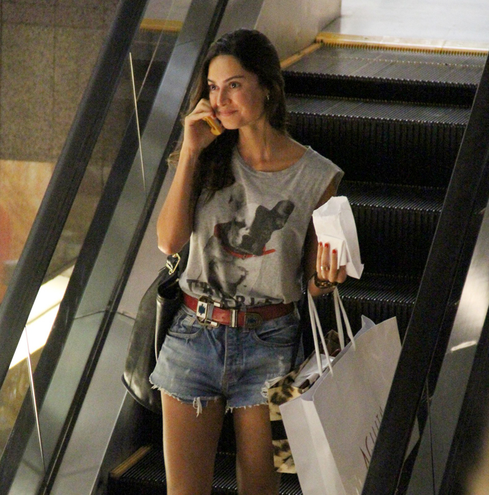 Thaila Ayala corre pão de queijo e fala ao celular no shopping