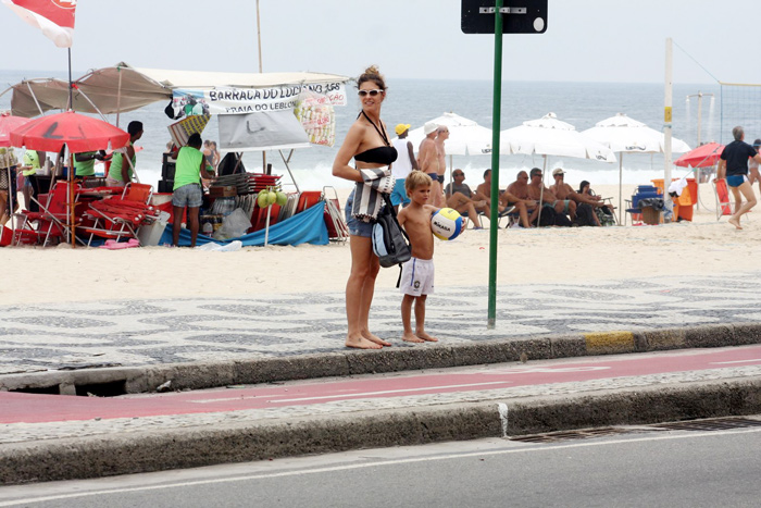 Fernanda Lima pedala com os gêmeos e vê celular ao mesmo tempo