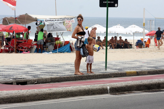 Fernanda Lima pedala com os gêmeos e vê celular ao mesmo tempo