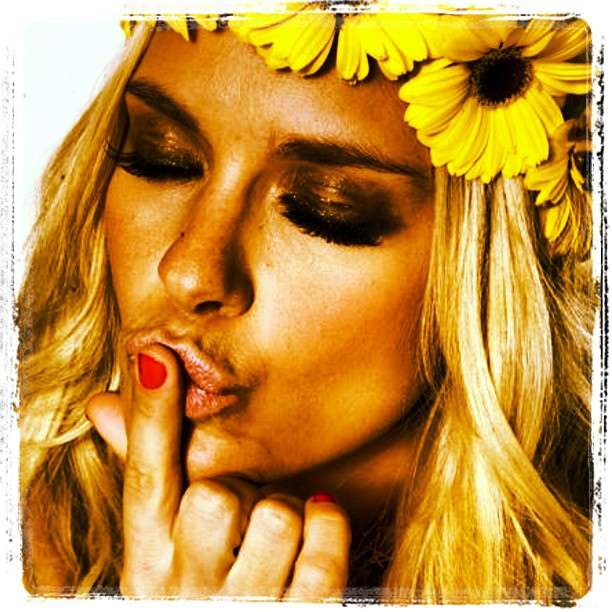 Com flores no cabelo, Carolina Dieckmann manda beijo em foto