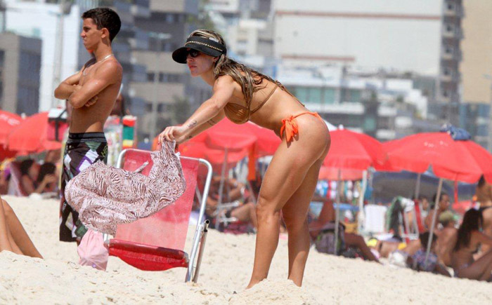 Joana Machado se diverte com o filho na praia do Leblon