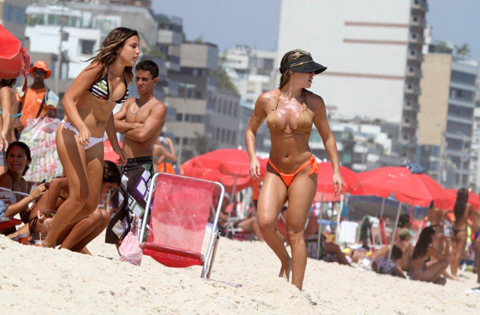 Joana Machado se diverte com o filho na praia do Leblon