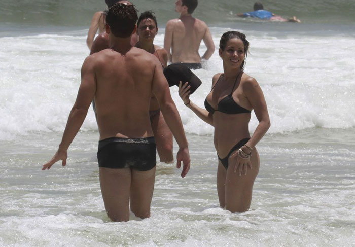 Danielle Winits curte praia com o namorado e o filho caçula