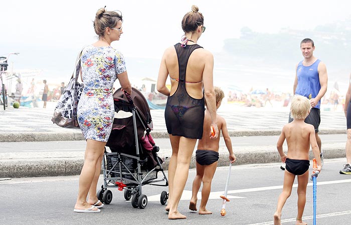 De vestido transparente, Fernanda Lima se diverte com gêmeos na praia