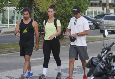 Camila Rodrigues e o marido caminham pela orla da Barra da Tijuca