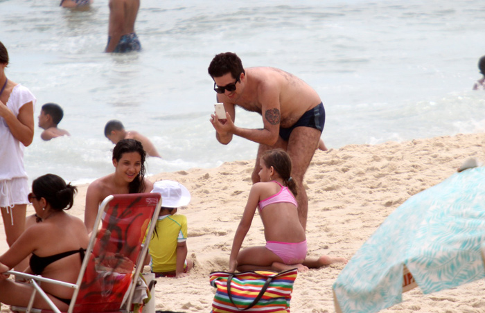  De sunguinha, Rogério Flausino curte praia com a mulher e filha