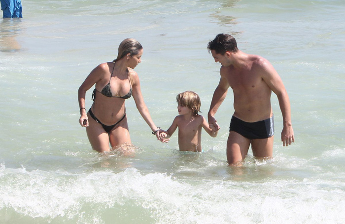 Danielle Winits curte praia com o filho e o namorado 