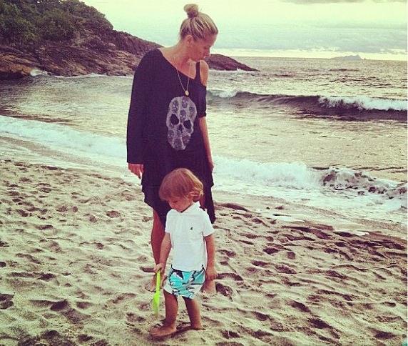 Adriane Galisteu caça siri na praia com o filho