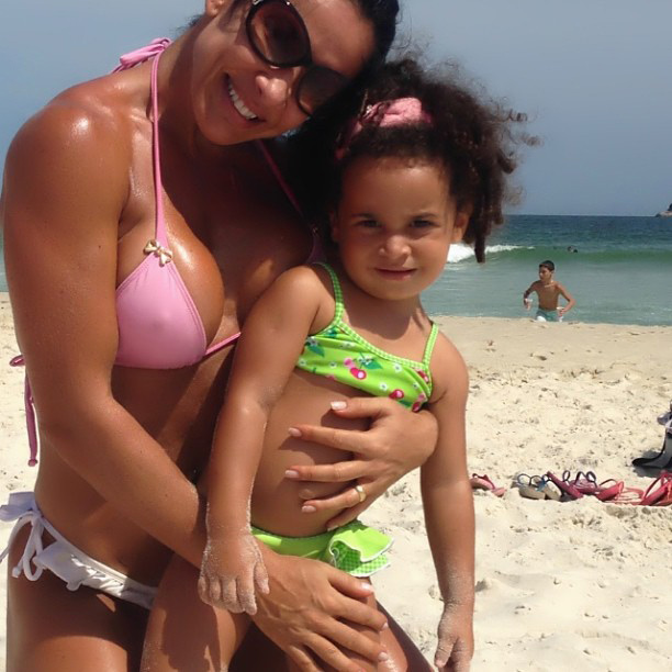 Com as cores da verde e rosa, Scheila Carvalho curte praia com a filha, no Rio